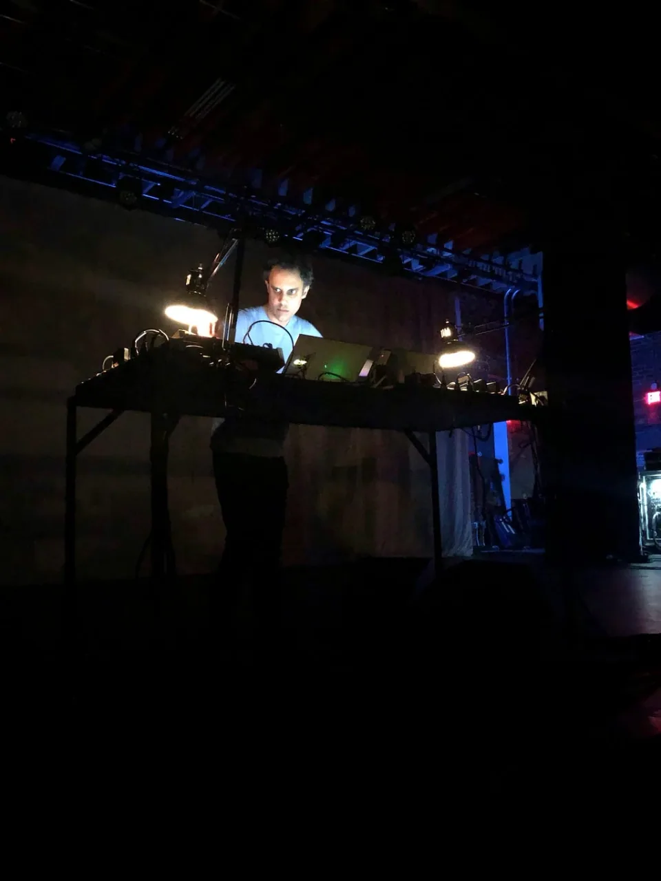 A DJ performing under blue lights at the festival