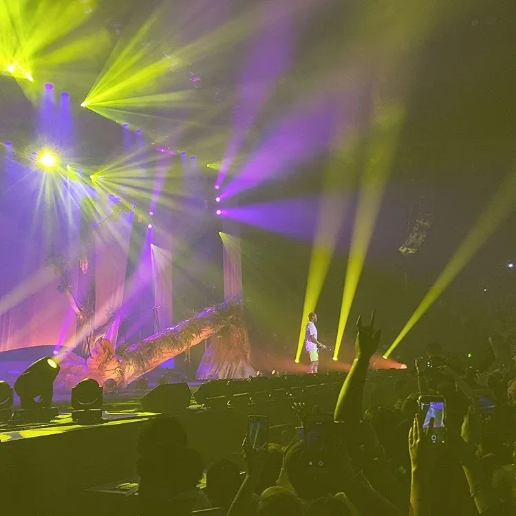 A concert stage lit in yellow and purple